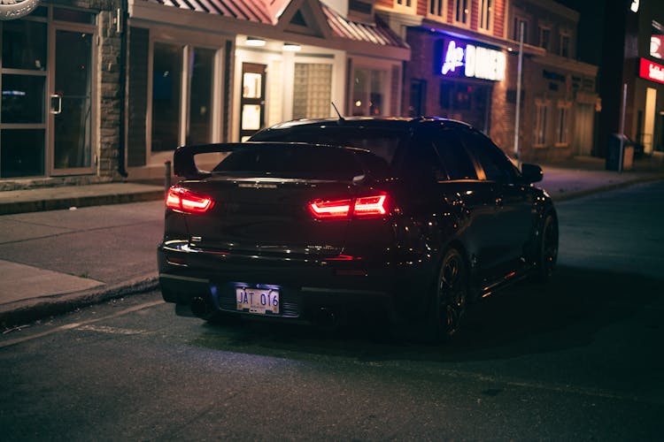 Back View Of A Black Car Parked On The Road