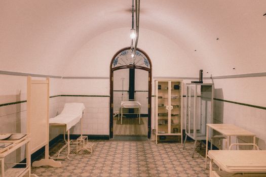 An old-fashioned hospital room with vintage medical furniture and equipment, evoking a retro clinical atmosphere.