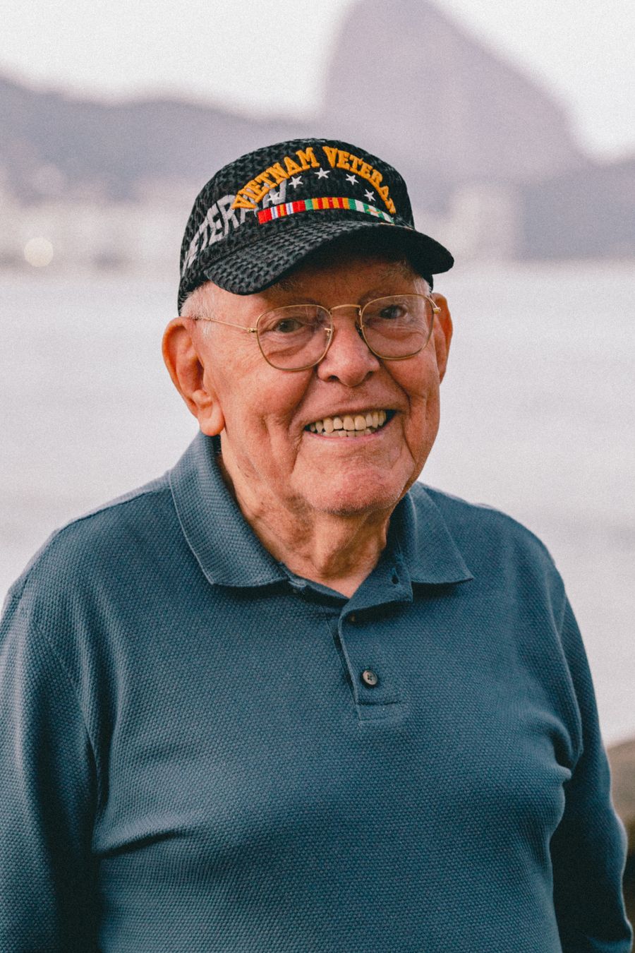 A smiling senior Veteran wearing his service cap