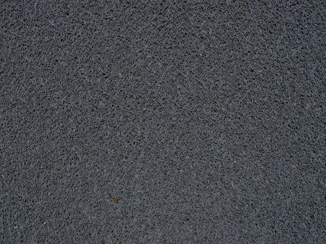 Detailed view of a gray synthetic doormat showcasing its fiber texture.