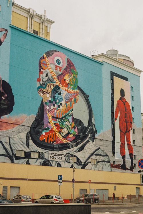 Free Colorful mural featuring astronaut imagery and abstract art on a city building. Stock Photo