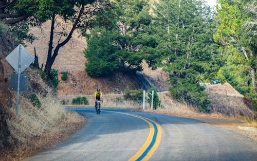 Free Man Riding a Bike on Mountain Road Stock Photo