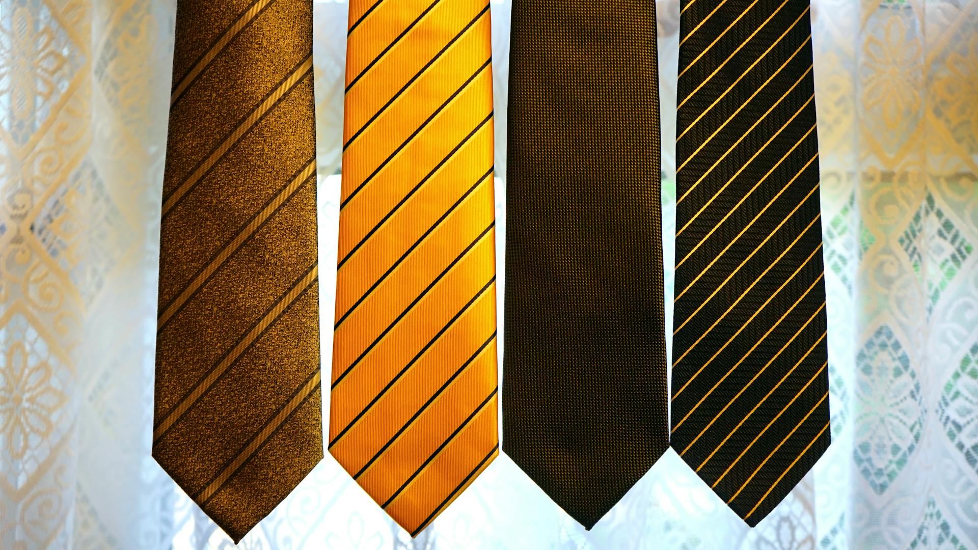 Four Assorted-color Neckties on Gray Textile