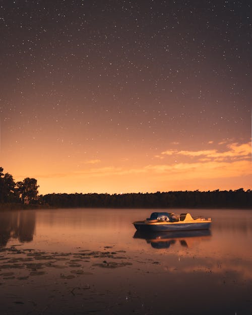 Free White and Black Boat on Lake during Sunset Stock Photo