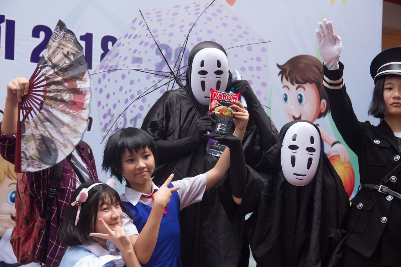 group of people in cosplay costumes posing at an anime themed celebrat