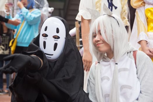 热闹的户外节日游行中，有身着动漫主题服装的角色扮演者