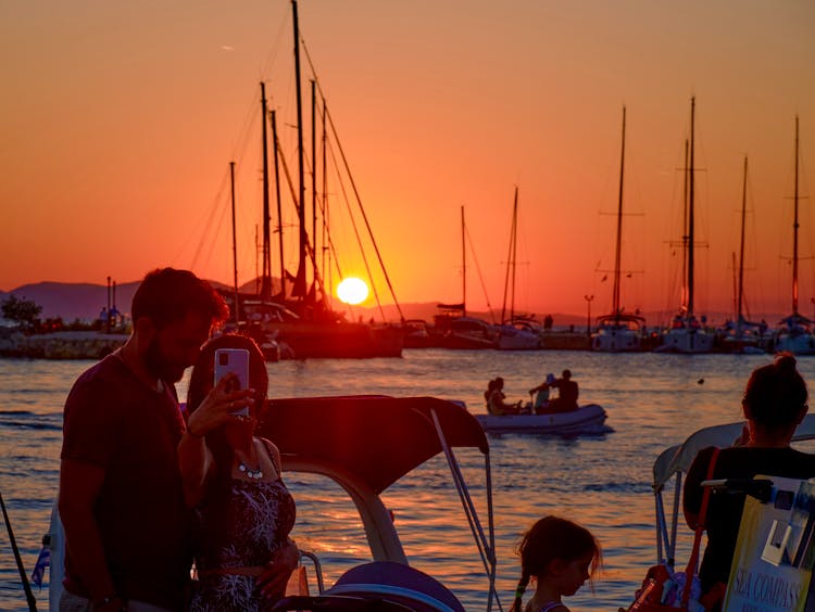 A Couple Taking A Selfie While On A Boat During The Golden Hour