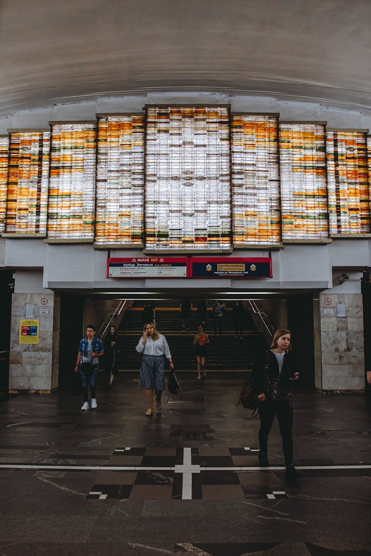 Passengers Walking In A Modernist Station With Glass Decoration