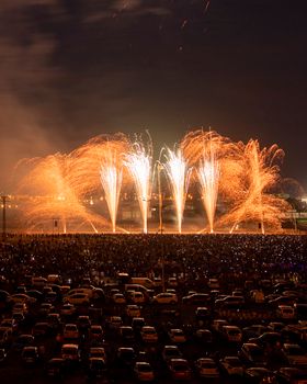 Stunning fireworks light up the night sky above a festive crowd gathered for celebration.