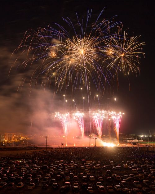 Free Dramatic fireworks burst over a bustling city at night, perfect for festive celebrations. Stock Photo