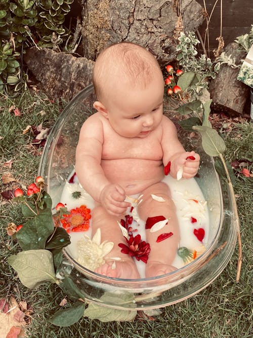 Free A Cute Baby on a Clear Bathtub With Milk and Petals Stock Photo