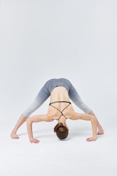 Woman practicing advanced yoga pose indoors showcasing flexibility and strength.