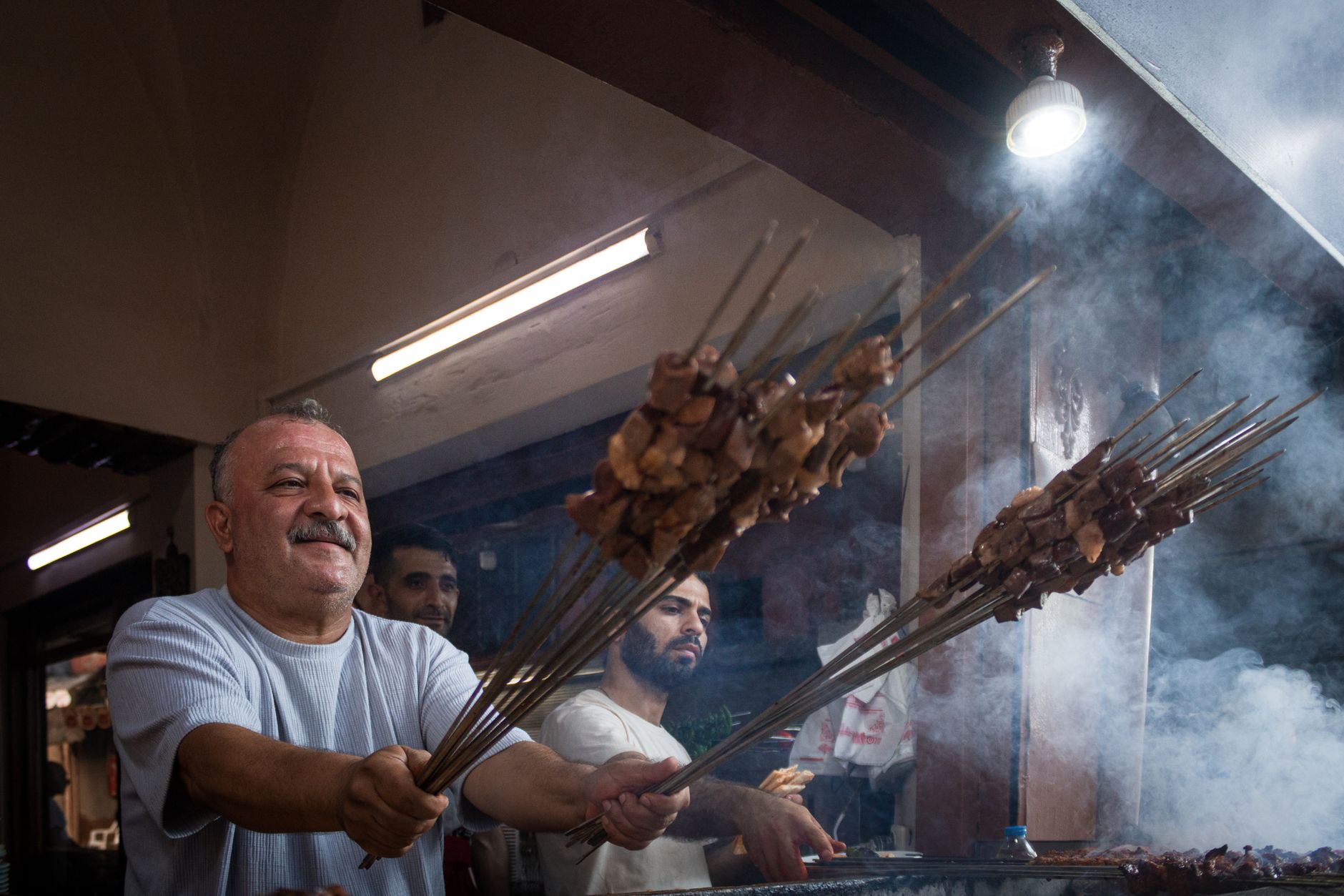 A street vendor grilling skewered meat and maize on a Nairobi pavement