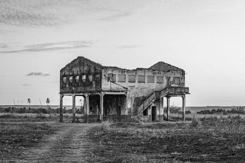 Grayscale Photo of Building on Grass Field