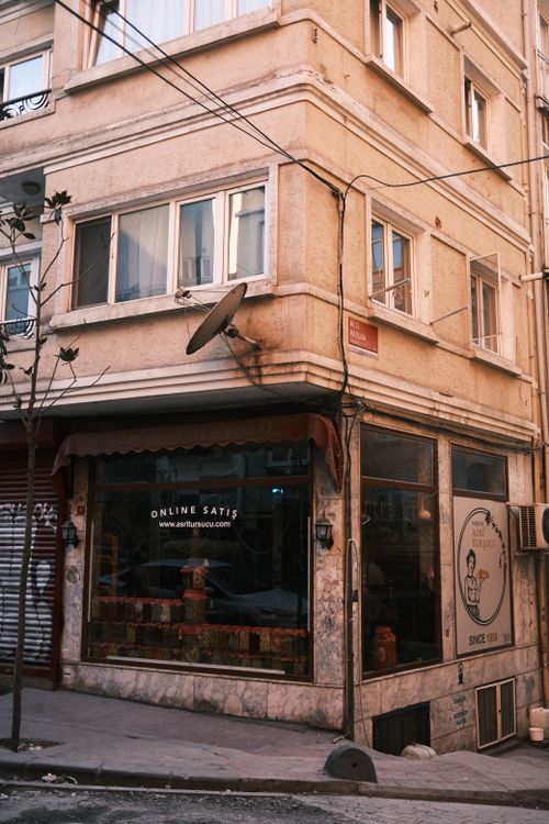 Free A street corner shop with vintage architecture in an urban area, showcasing online sales. Stock Photo