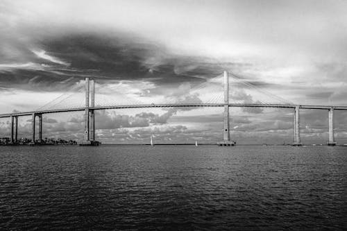 Grayscale Photo of the Bridge Over the Sea