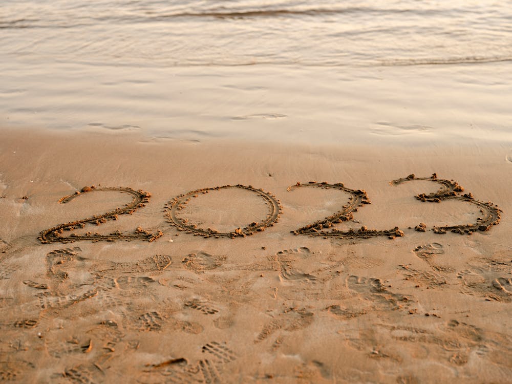 Free Writing 2023 on sand beach Stock Photo