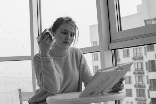 Grayscale Photo of a Beautiful Woman Reading a Book