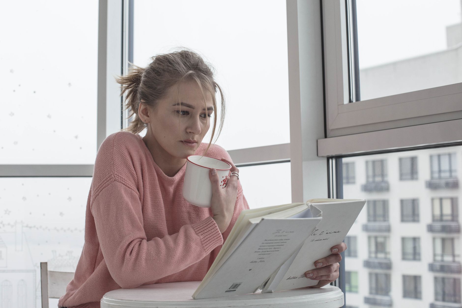 Casual woman enjoying a book with coffee by a bright window scene.. casual, woman, enjoying