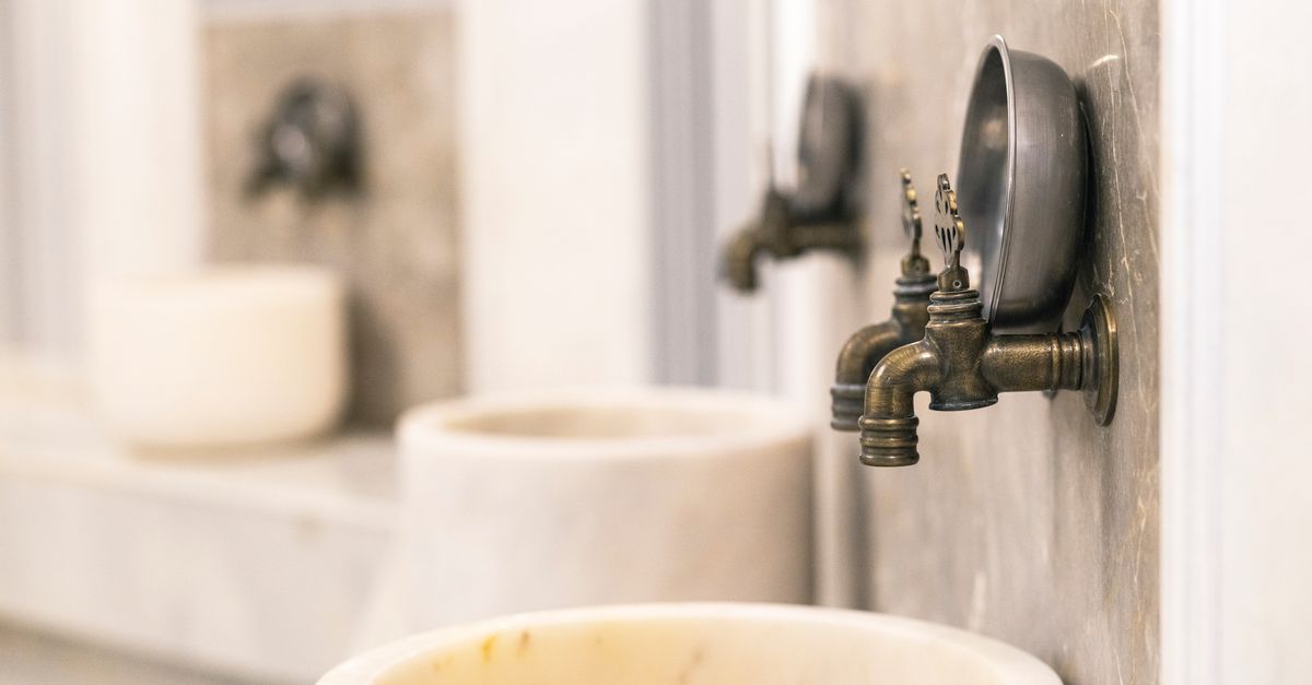 Close-up of vintage Turkish bath faucets with marble basins, showcasing traditional design.