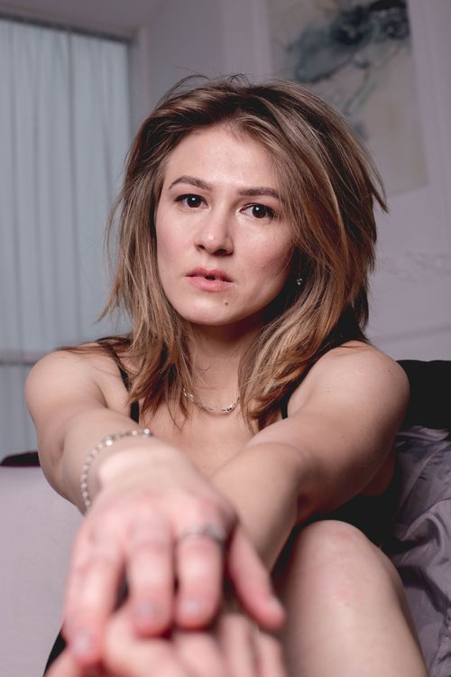Free Portrait of a woman with messy hair and jewelry showcasing elegance indoors. Stock Photo