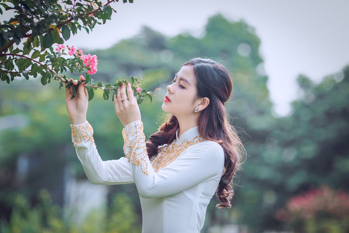 Free Shallow Focus Photography Of Woman Smelling Flower Stock Photo