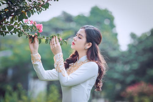 Free Shallow Focus Photography Of Woman Smelling Flower Stock Photo