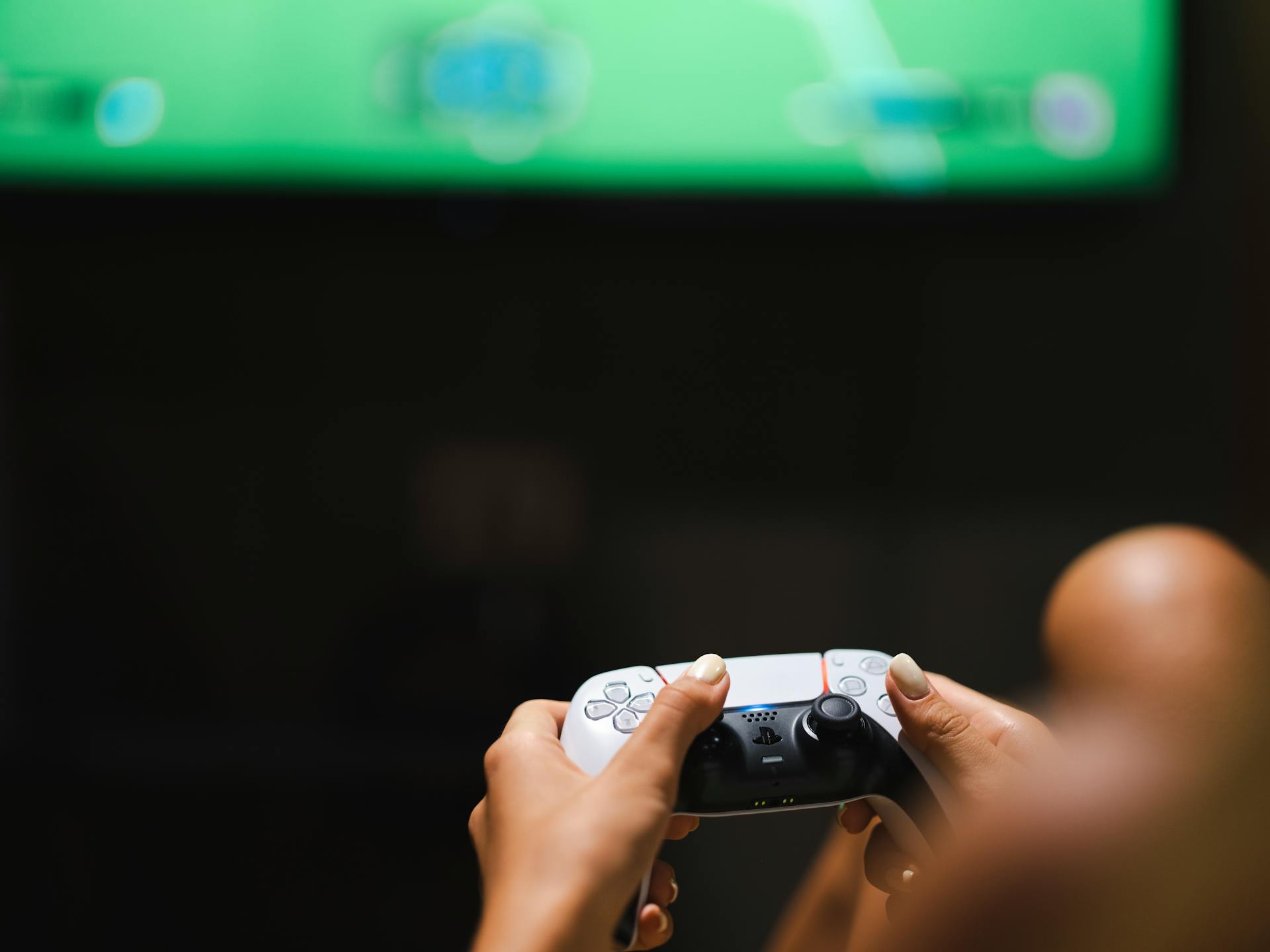 Close-up of hands holding a modern video game controller while gaming.