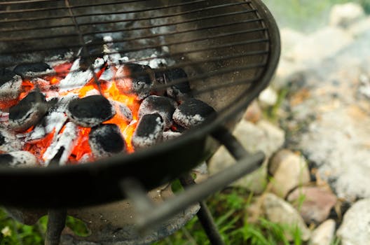 Charcoal glowing intensely in a barbecue grill, perfect for grilling and outdoor cooking on a summer day.
