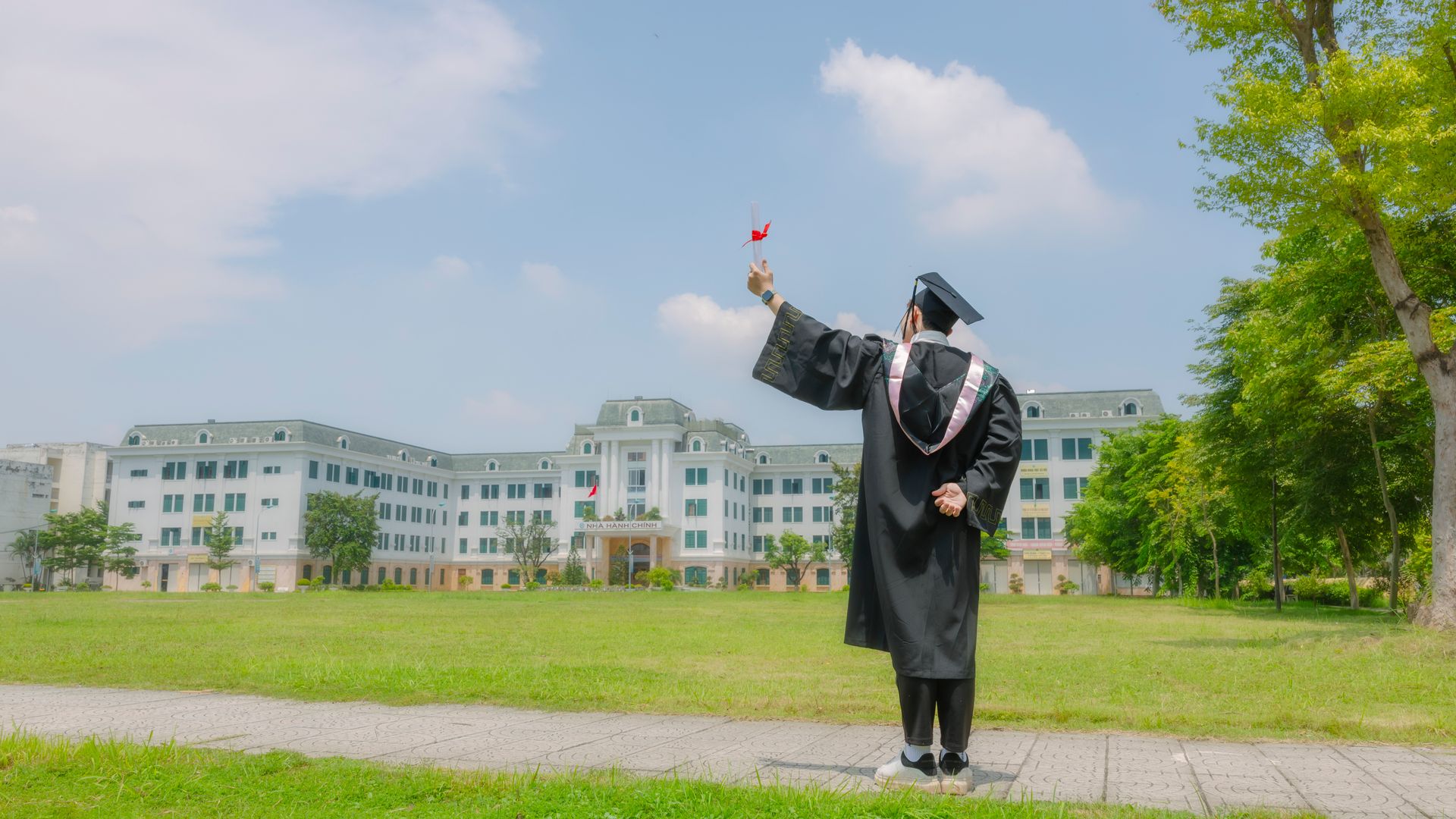 Modafinil for Graduate School Research: The Ultimate Guide A graduate in academic regalia celebrates victory on a sunny day outdoors — modafinil for graduate school research