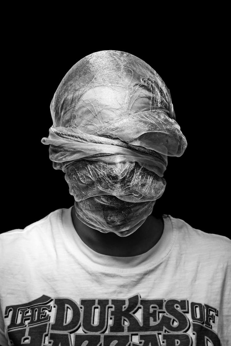 Man With Cover On Head And Face On Black Background