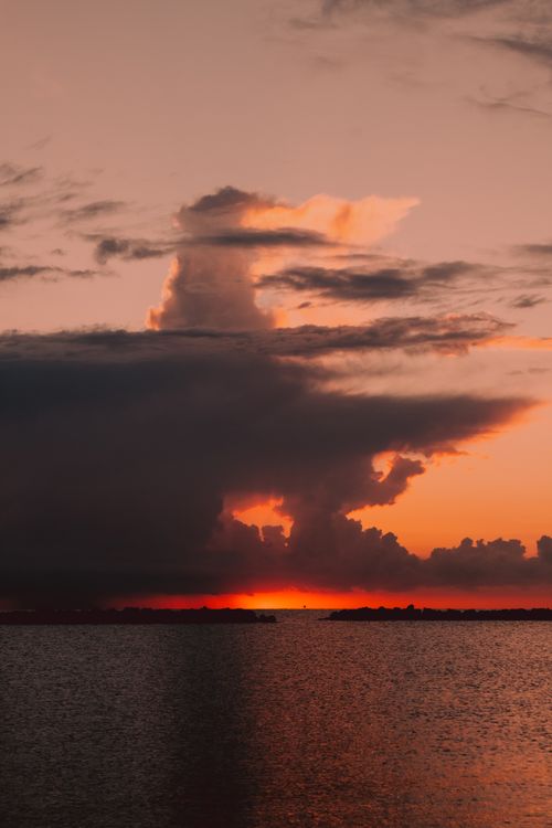 Free A stunning sunset with vibrant colors reflecting on the sea at Igea Marina, Italy. Stock Photo