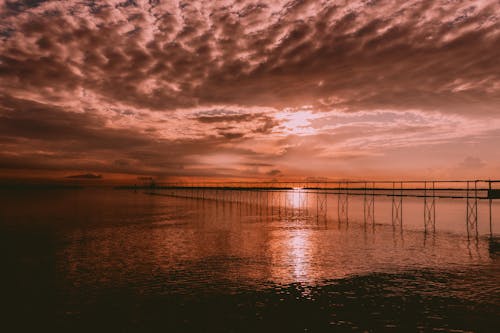 Body of Water Under Cloudy Sky during Sunset