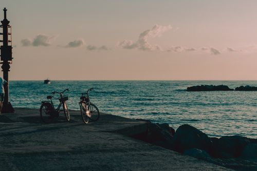 Free Serene view of parked bicycles by the sea at sunset in Bellaria, Italy. Stock Photo