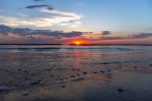 Free Vibrant sunset over a tranquil beach with reflection on the water. Perfect serene nature scene. Stock Photo