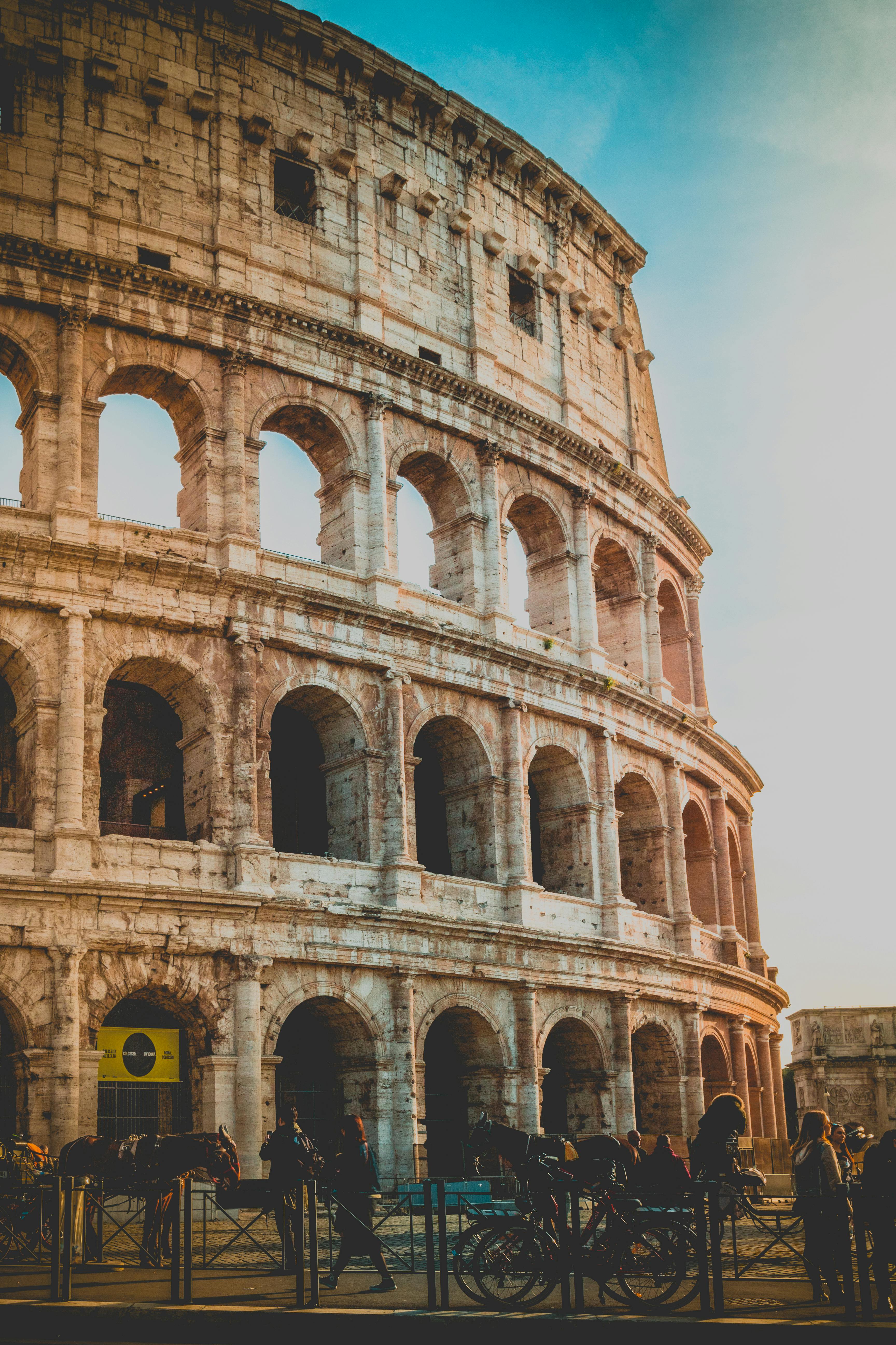 Free Sunset view of Rome's iconic Colosseum, a masterpiece of ancient architecture. Stock Photo