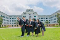 Happy Graduates Standing Outside a School