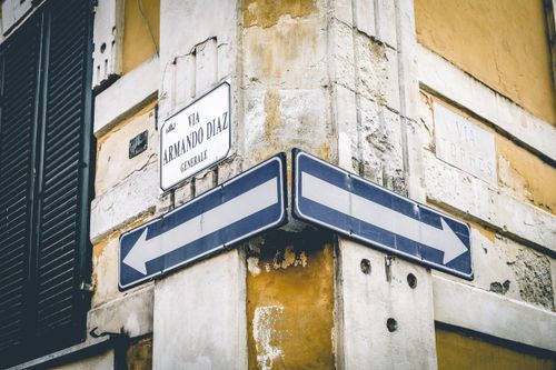 Free A rustic urban corner with directional signs and vintage architecture. Stock Photo