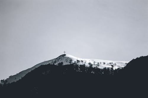 A Snow Covered Mountain with Cross on Top