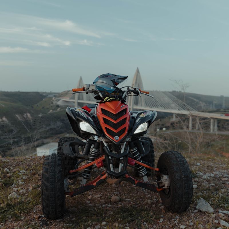 Orange KTM dirt bike parked on an Ohio forest trail with fall foliage in background