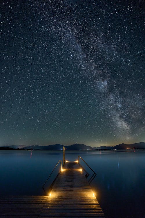 A Wooden Dock Near the Body of Water Under the Starry Sky · Free Stock ...