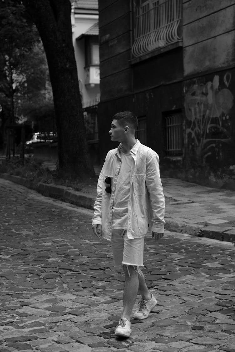 Young Man In Shorts And Jacket Crossing Street