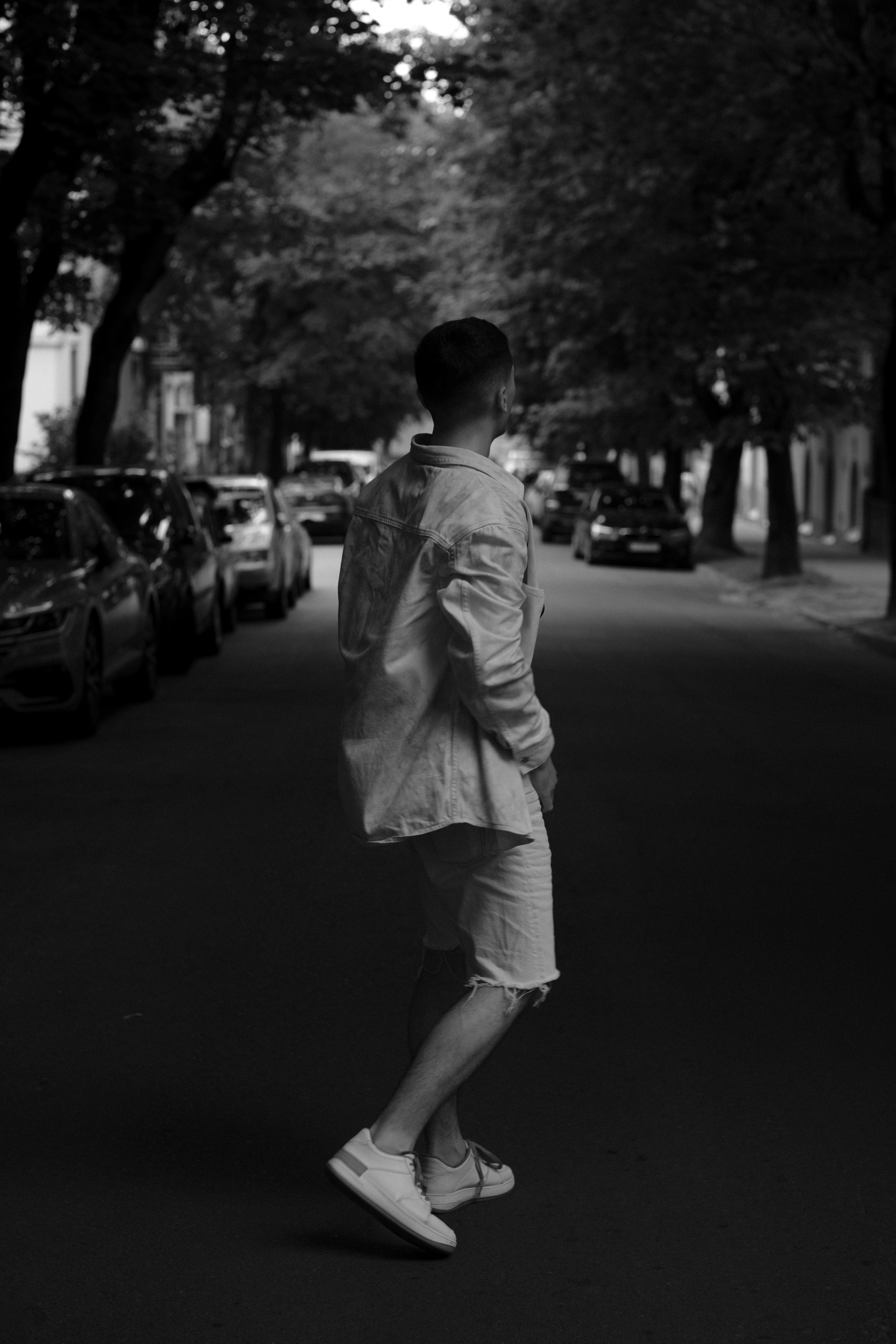 Grayscale Photo of a Person Walking on the Sidewalk with Street Lights ...