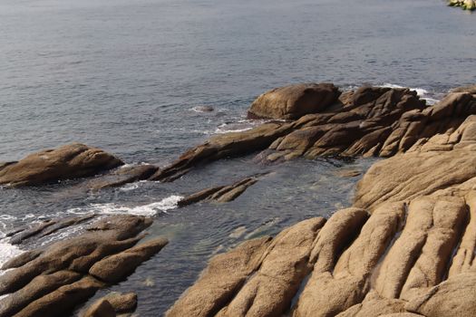 View of a rocky ocean coastline with unique eroded formations during low tide.. view, rocky, ocean