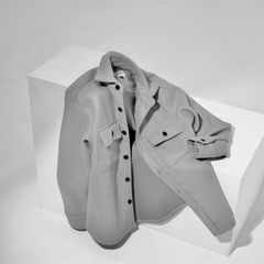 Grey wool-blend overshirt on a studio plinth — photo by Fahmi Garna on Pexels