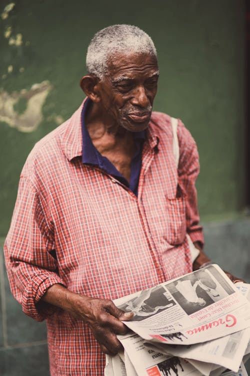 Elderly Man Holding Newspapers