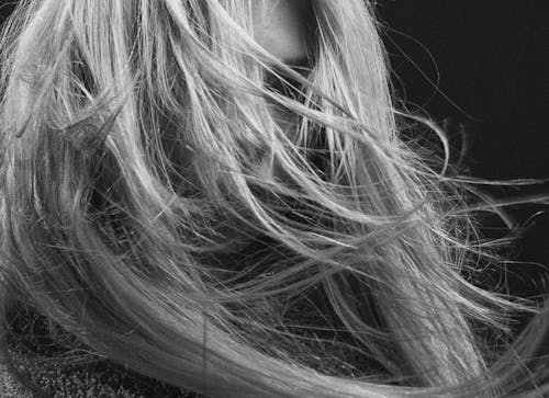 Grayscale Photo of Woman's Face Covered with Her Hair