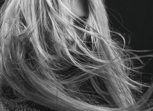 Free Artistic black and white close-up of a person with wind-swept hair, conveying mystery and elegance. Stock Photo