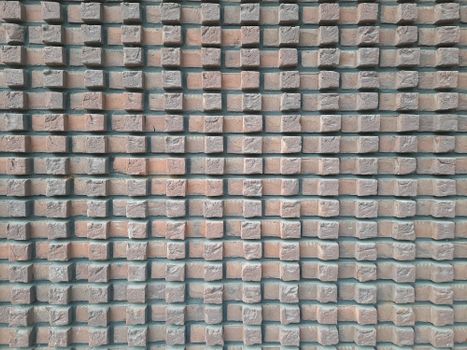 Close-up texture of a structured brick wall creating a geometric pattern.