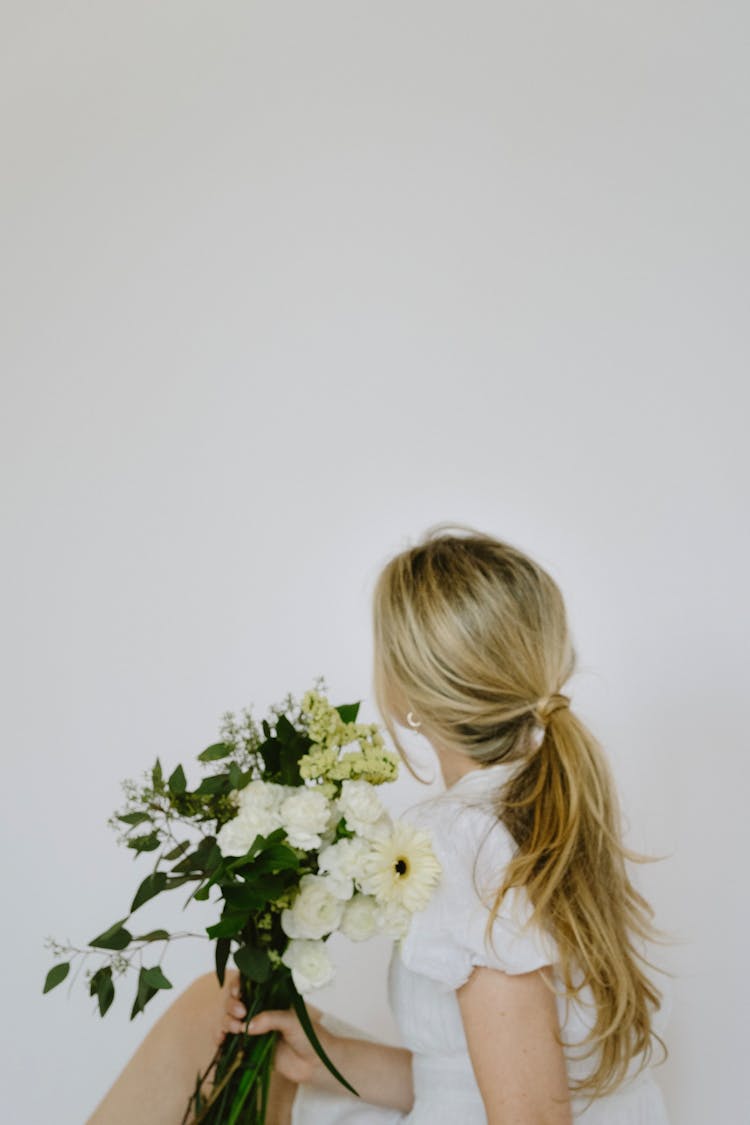 Blonde Woman With Long Tied Hair Holding Bouquet Of White Flowers